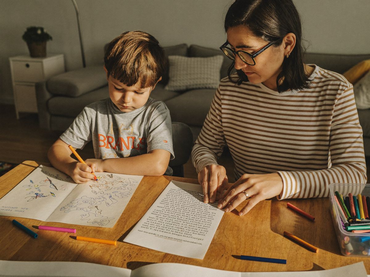 Mãe lendo a curiosidade enquanto o filho pinta